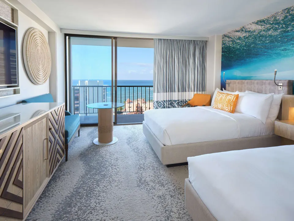 Two-bed guest room with ocean-facing balcony at OUTRIGGER Waikiki Beachcomber Hotel.