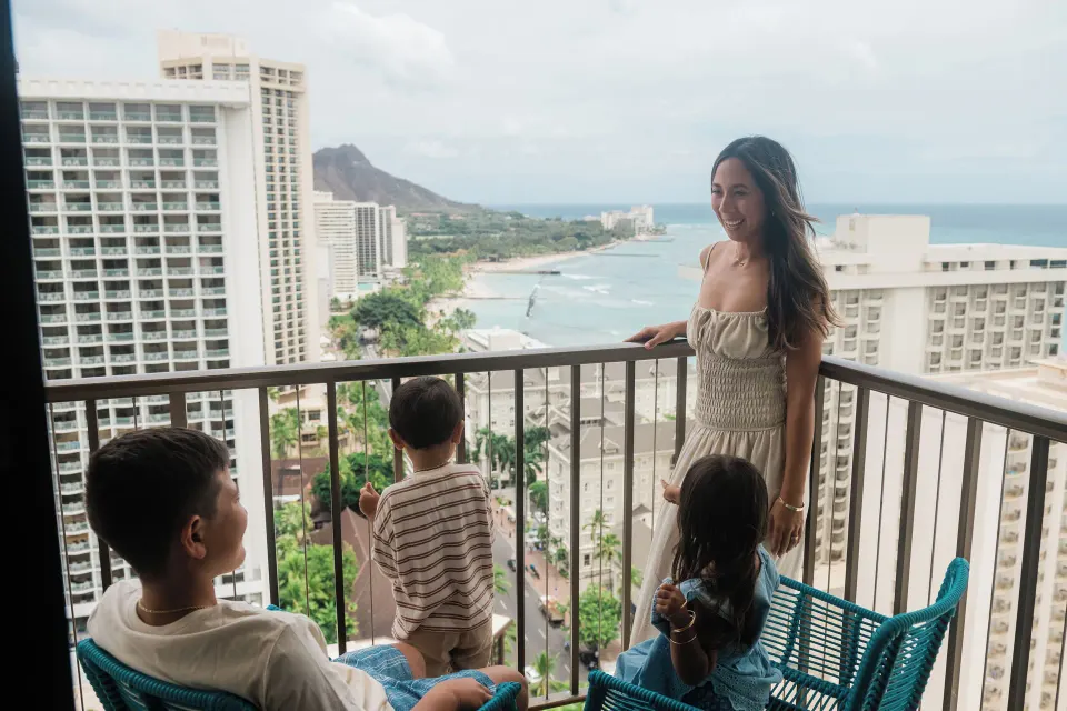 Family on an Ocean View room balcony at OUTRIGGER Waikiki Beachcomber Hotel overlooking Waikiki.