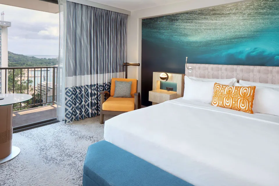 Ocean View king room with balcony and ocean glimpse at OUTRIGGER Waikiki Beachcomber Hotel.