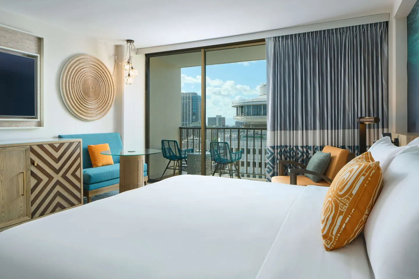 Partial Ocean View room with bed, sofa, and balcony at OUTRIGGER Waikiki Beachcomber Hotel.