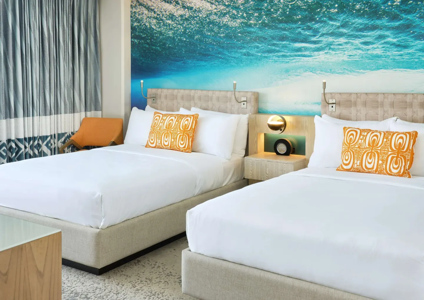 Two beds with ocean mural in a Partial Ocean View room at OUTRIGGER Waikiki Beachcomber Hotel.