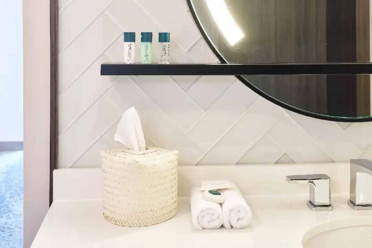 Bathroom vanity with mirror and towels in a Partial Ocean View room at Outrigger Waikiki Beachcomber Hotel.