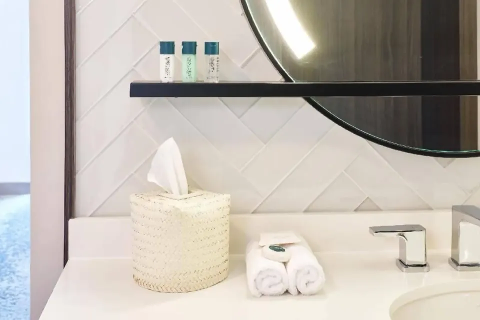 Bathroom vanity with mirror and towels in a Partial Ocean View room at Outrigger Waikiki Beachcomber Hotel.