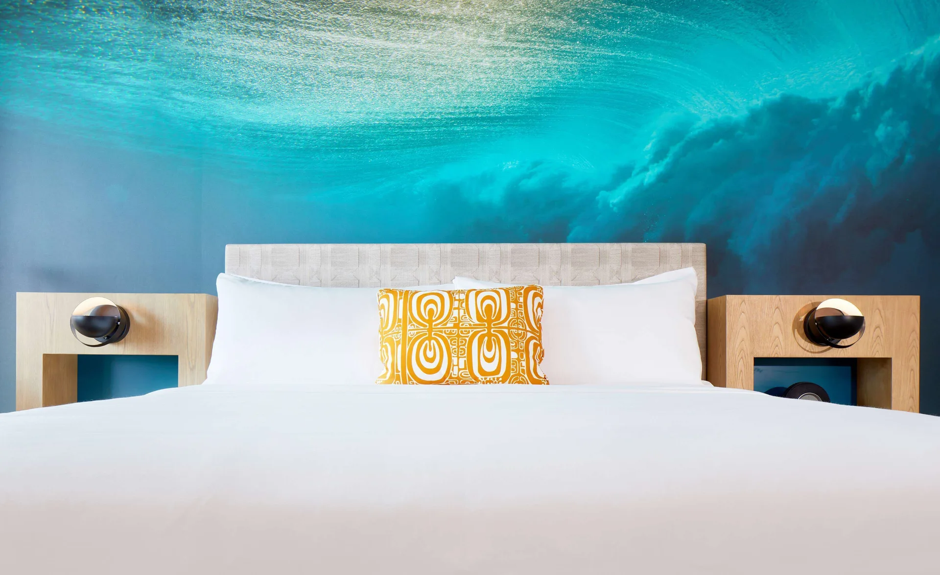Guest room bed with ocean mural at OUTRIGGER Waikiki Beachcomber Hotel.