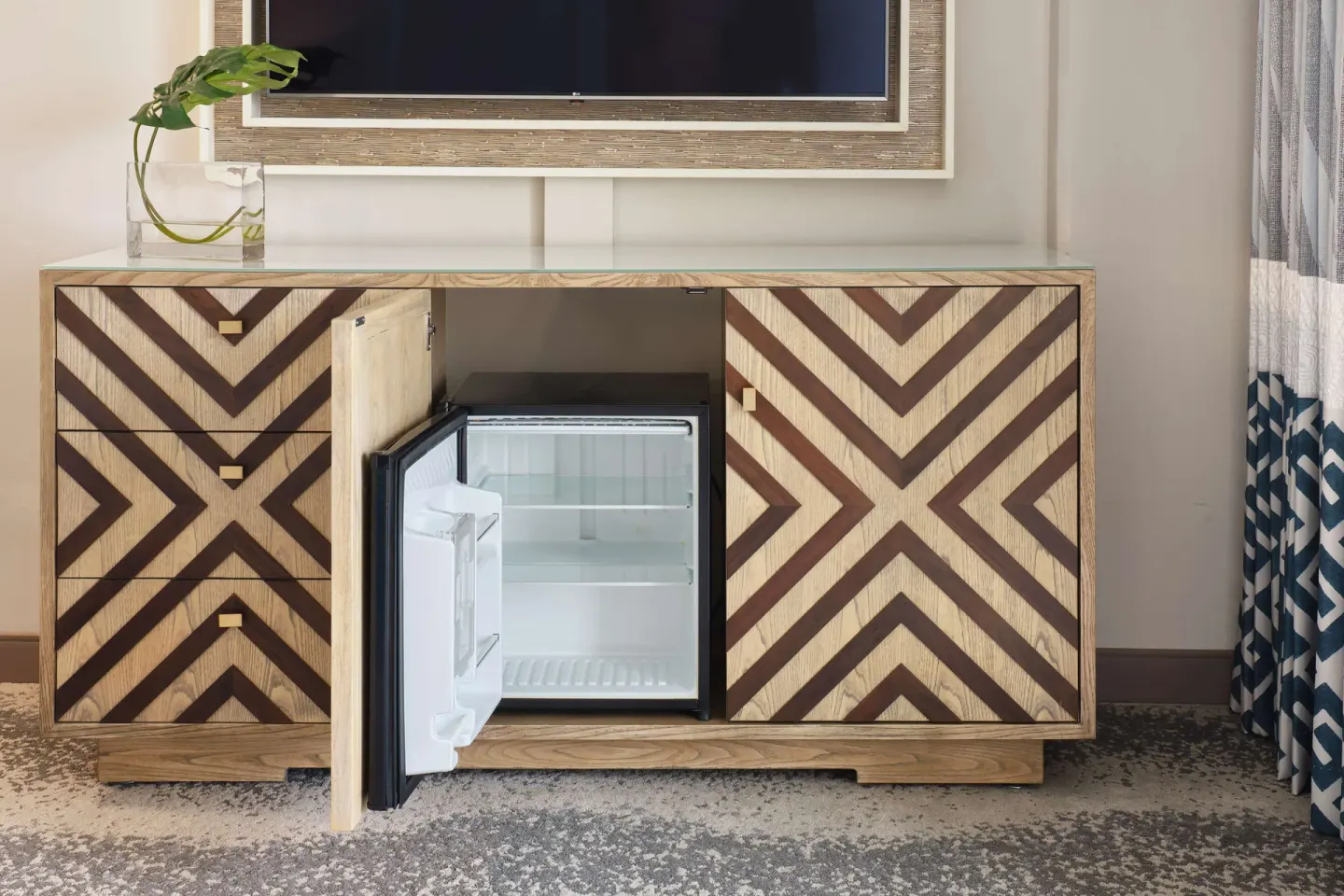 Guest room media cabinet with open mini refrigerator at OUTRIGGER Waikiki Beachcomber Hotel.