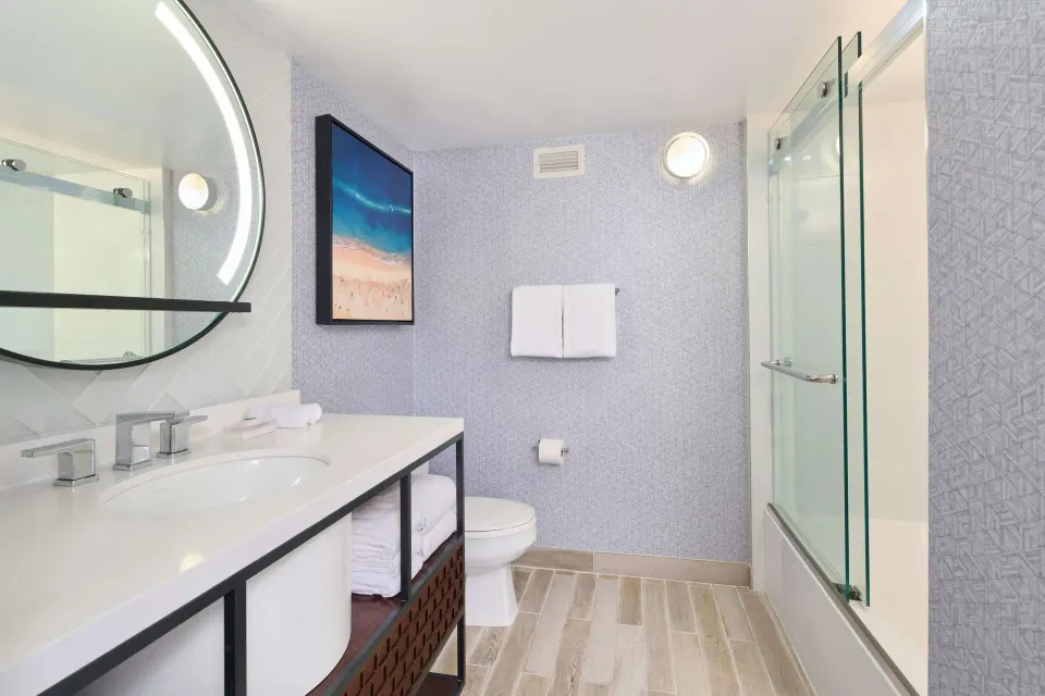 Suite bathroom with vanity, toilet, and glass shower at OUTRIGGER Waikiki Beachcomber Hotel.