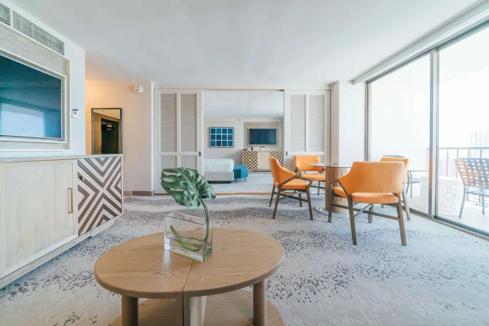Ocean View Suite seating area with balcony doors at OUTRIGGER Waikiki Beachcomber Hotel.