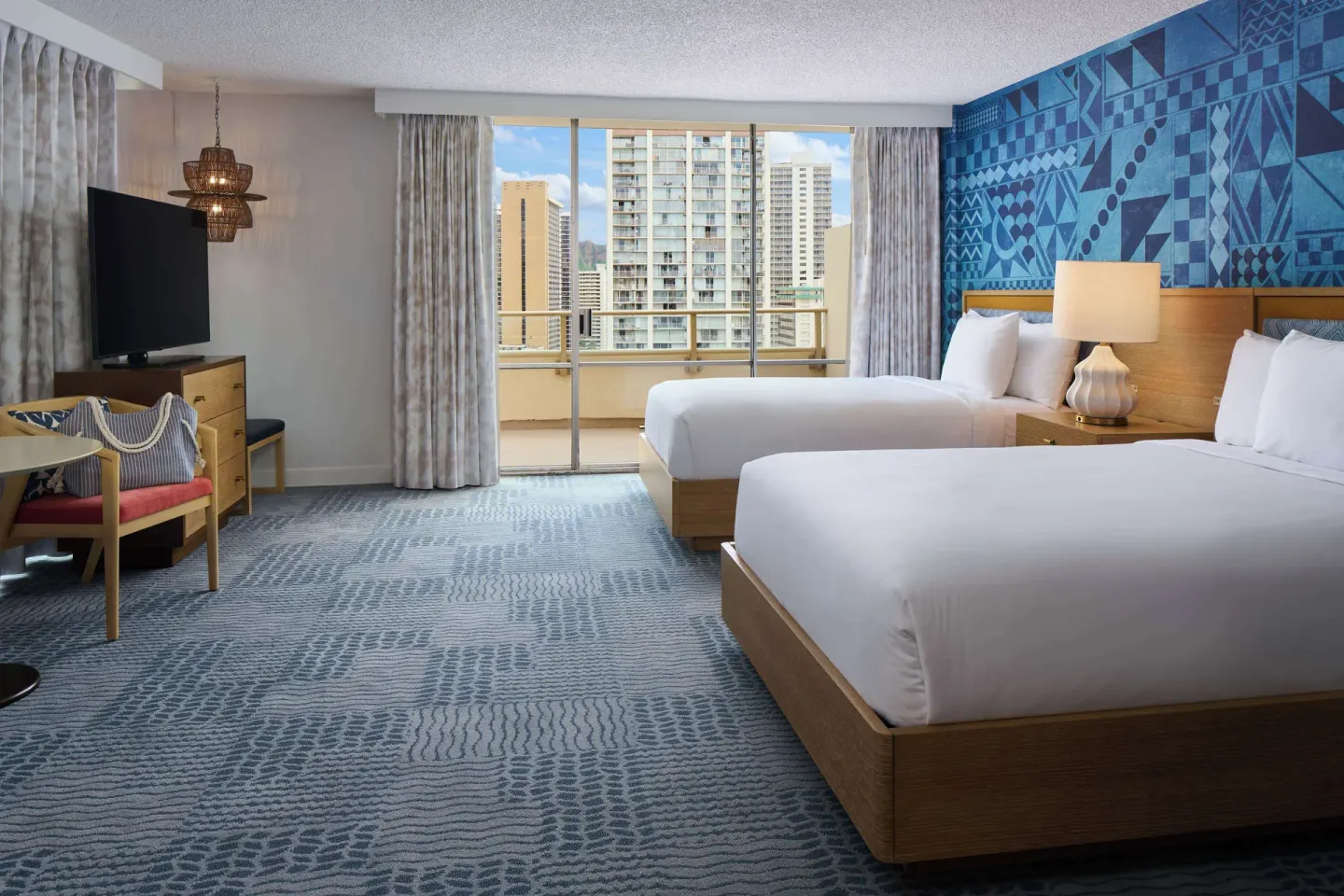 Spacious two-bed guest room with balcony doors at OUTRIGGER Waikiki Paradise Hotel.