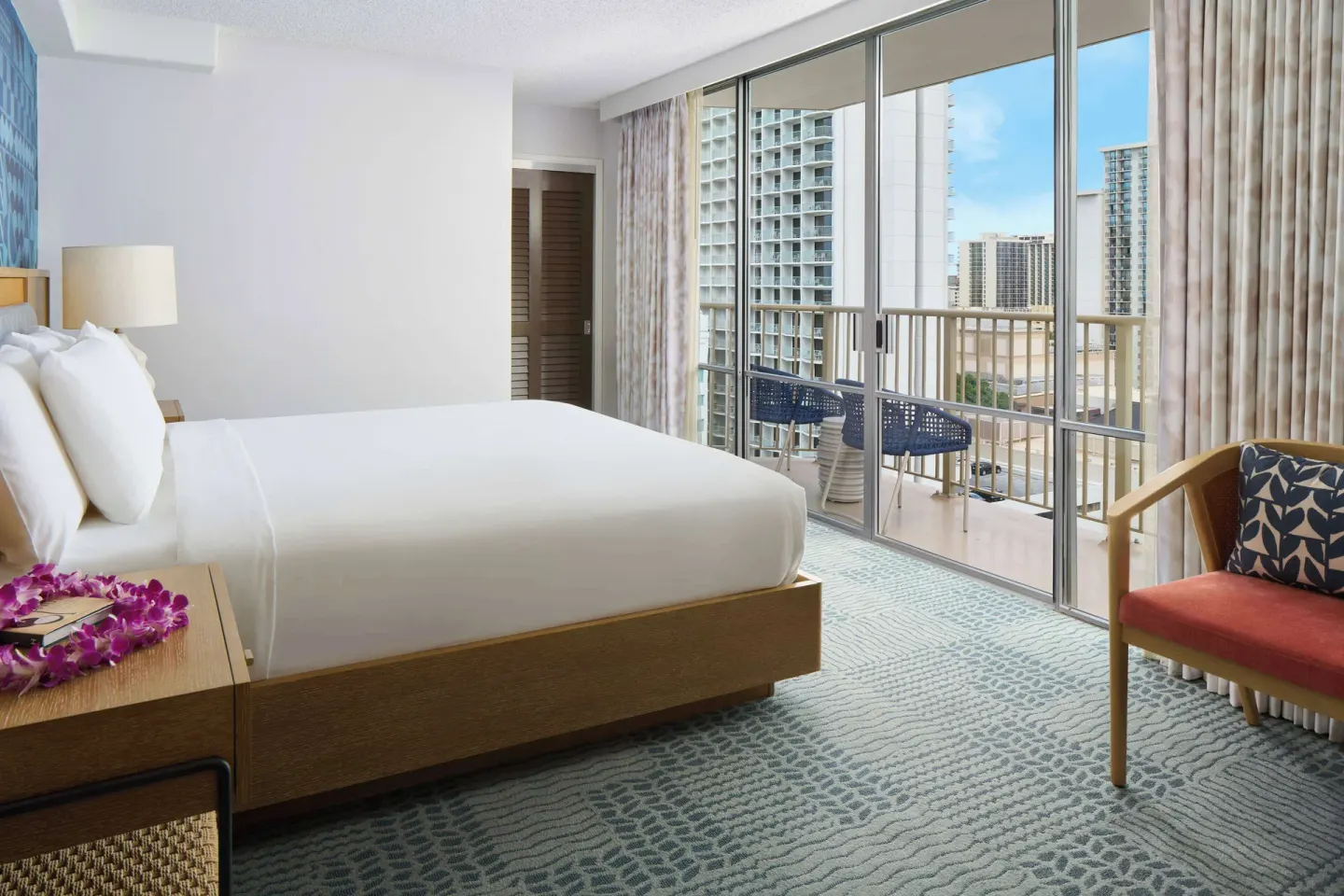King bed guest room with balcony seating at OUTRIGGER Waikiki Paradise Hotel.