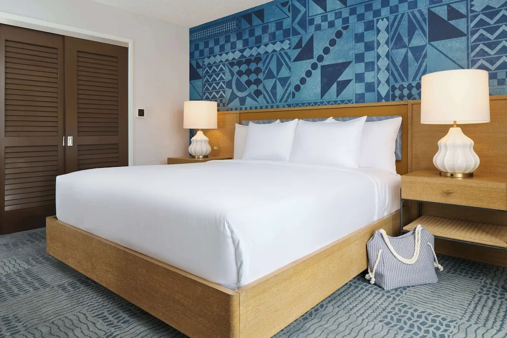 King bed with bedside lamps and blue wall at OUTRIGGER Waikiki Paradise Hotel.
