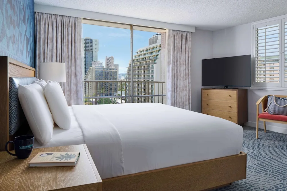 King-bed guest room with balcony city view at OUTRIGGER Waikiki Paradise Hotel.