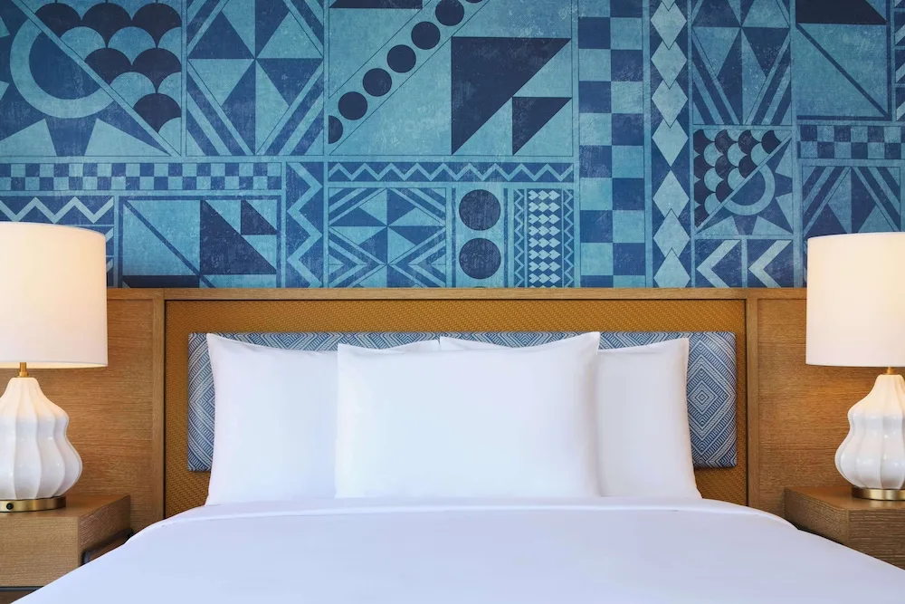 Close-up of a king bed and blue accent wall at OUTRIGGER Waikiki Paradise Hotel.