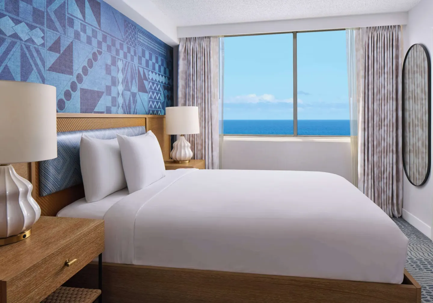 King-bed guest room with ocean view window at OUTRIGGER Waikiki Paradise Hotel.