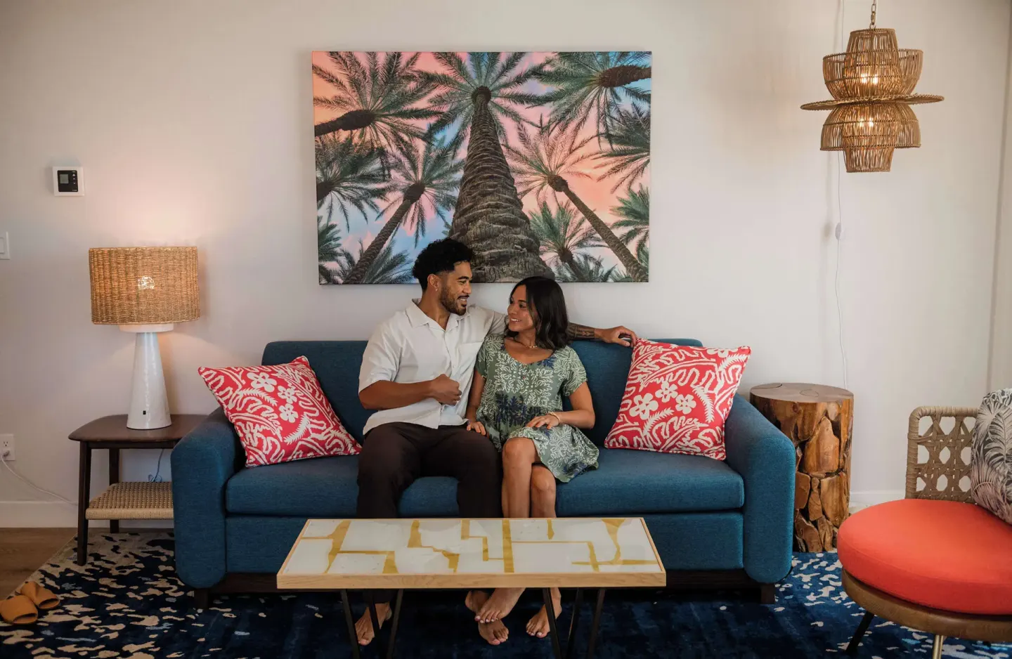 Couple seated on a blue guest room sofa at OUTRIGGER Waikiki Paradise Hotel.