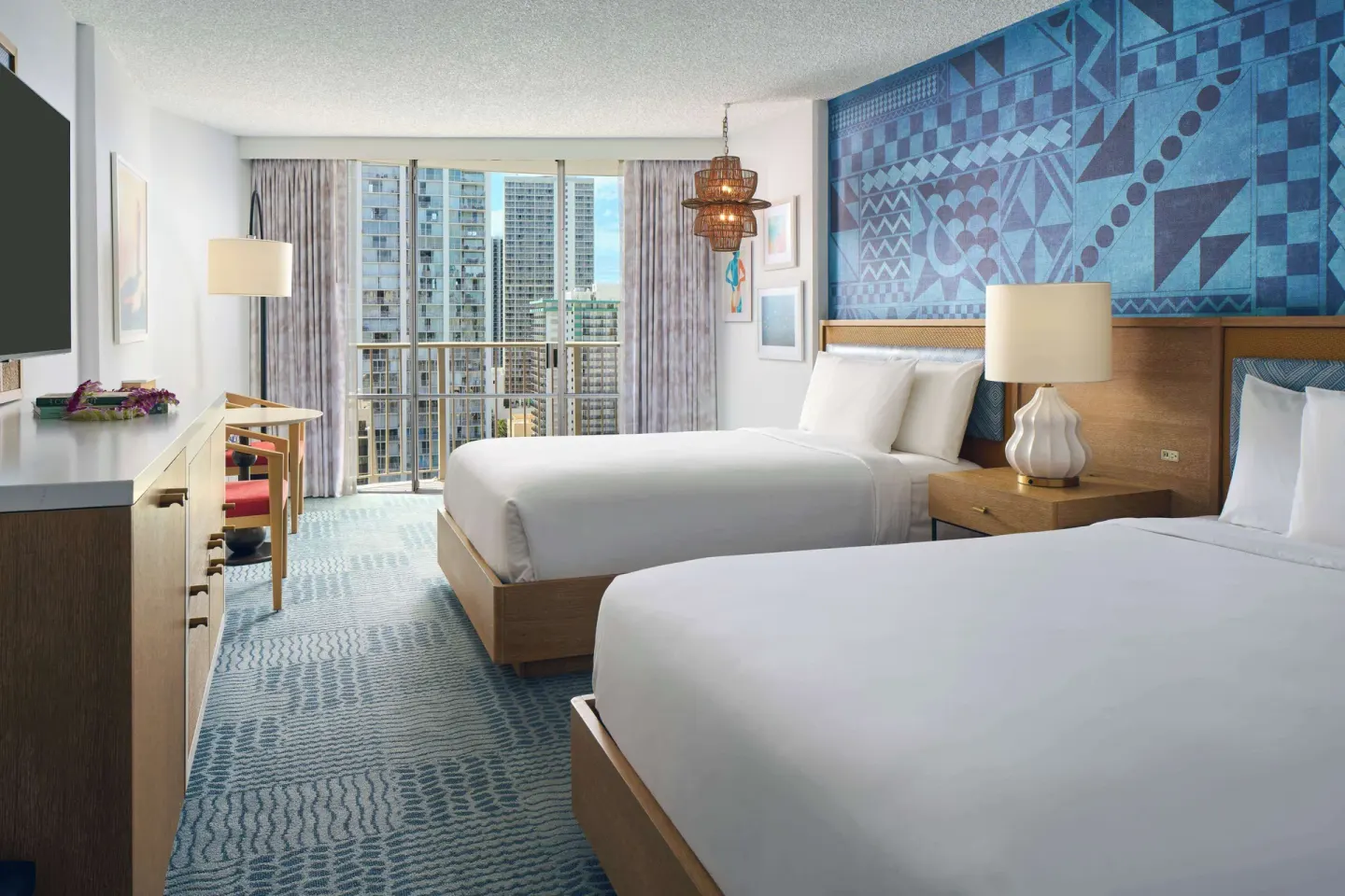 Two-bed guest room with city-facing balcony at OUTRIGGER Waikiki Paradise Hotel.