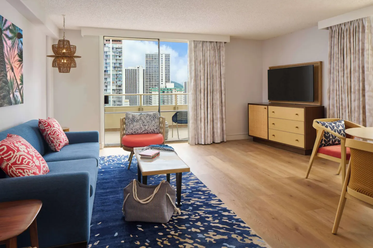Suite living area with sofa and balcony view at OUTRIGGER Waikiki Paradise Hotel.