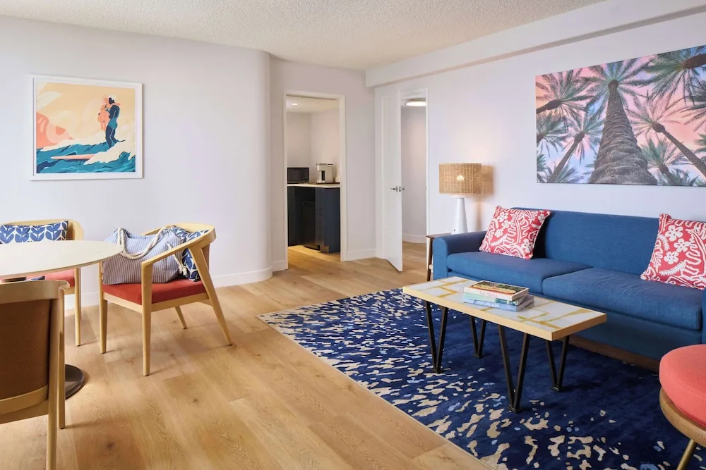 Suite lounge and dining area with tropical artwork at OUTRIGGER Waikiki Paradise Hotel.