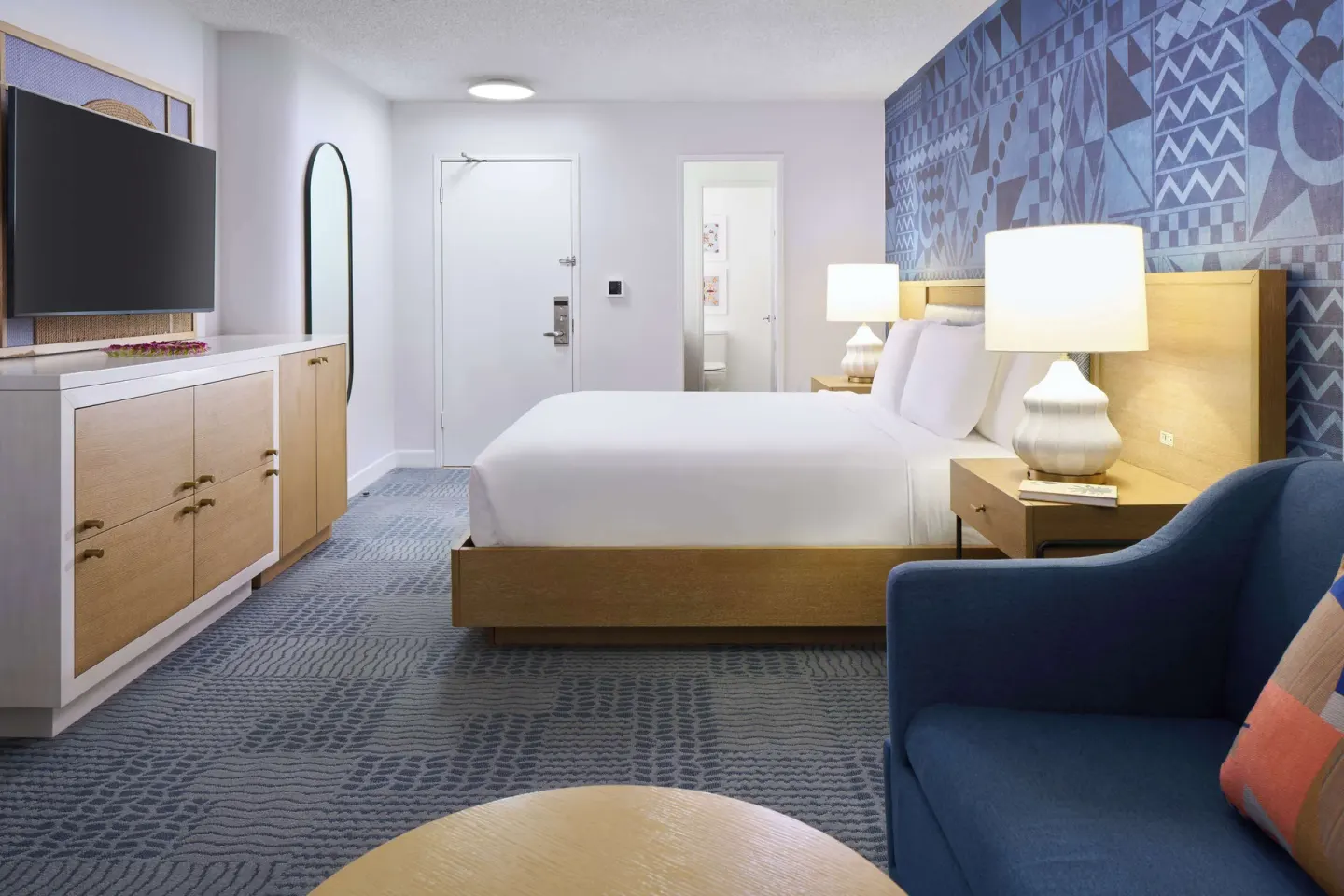 King guest room with dresser and blue chair at OUTRIGGER Waikiki Paradise Hotel.