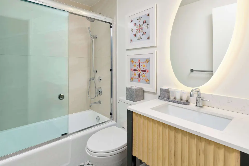 Guest bathroom with tub shower and vanity at OUTRIGGER Waikiki Paradise Hotel.