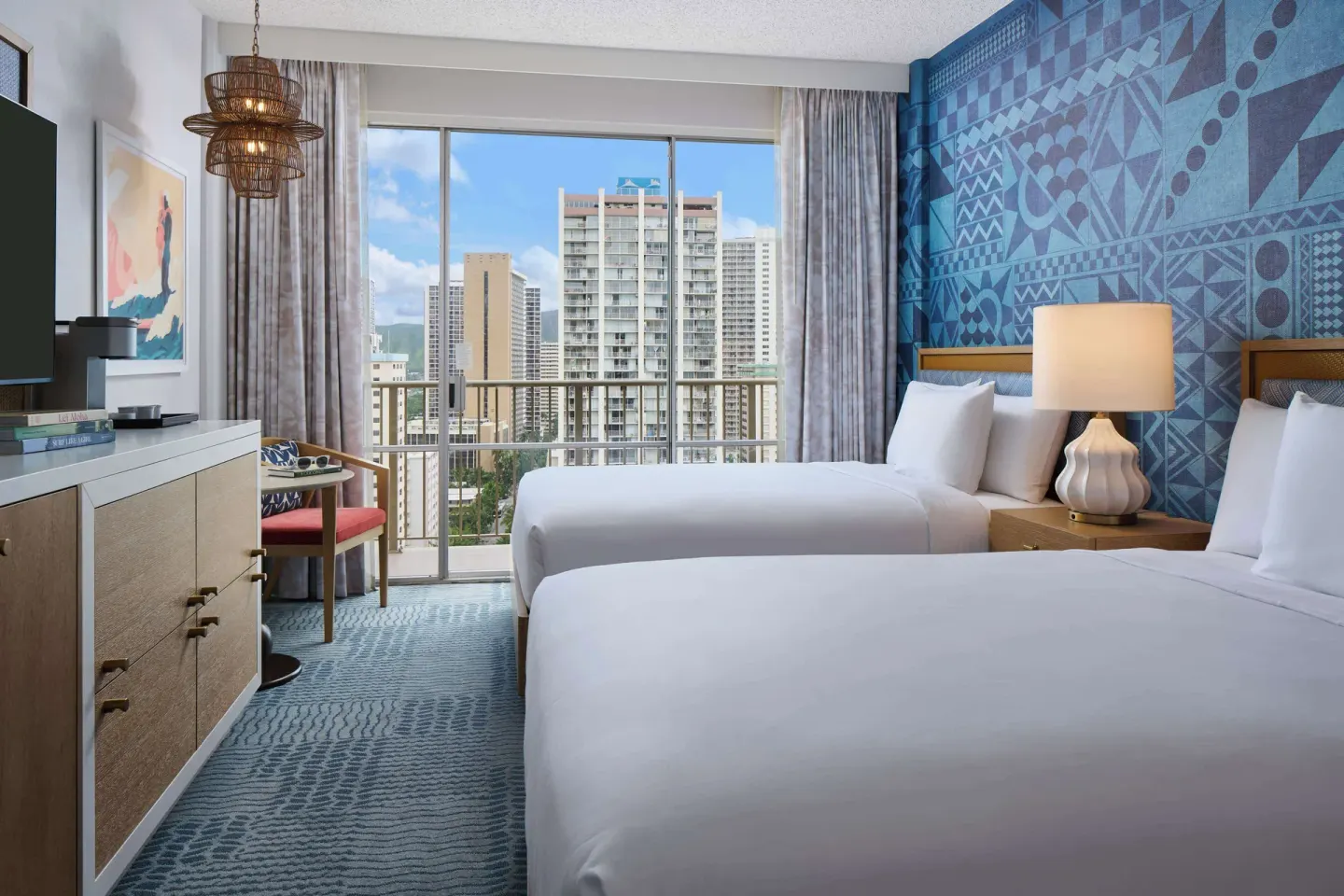 Two-bed guest room with city-view balcony at OUTRIGGER Waikiki Paradise Hotel.