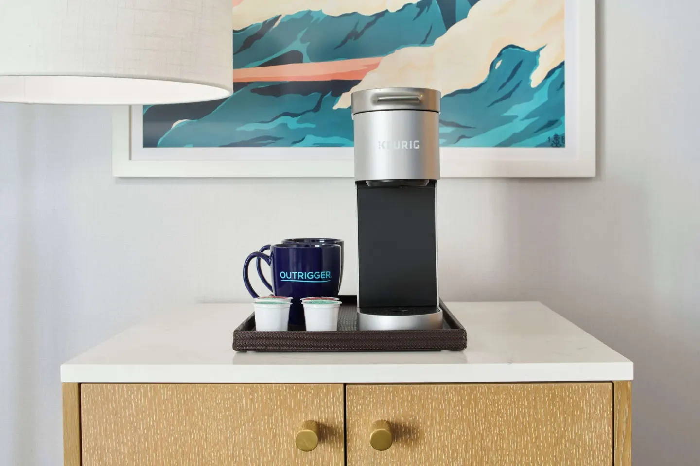 In-room coffee setup with mug and single-serve cups at OUTRIGGER Waikiki Paradise Hotel.