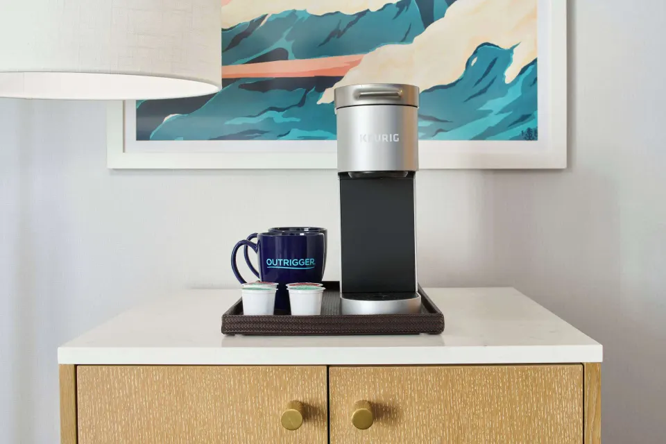 In-room coffee setup with mug and single-serve cups at OUTRIGGER Waikiki Paradise Hotel.