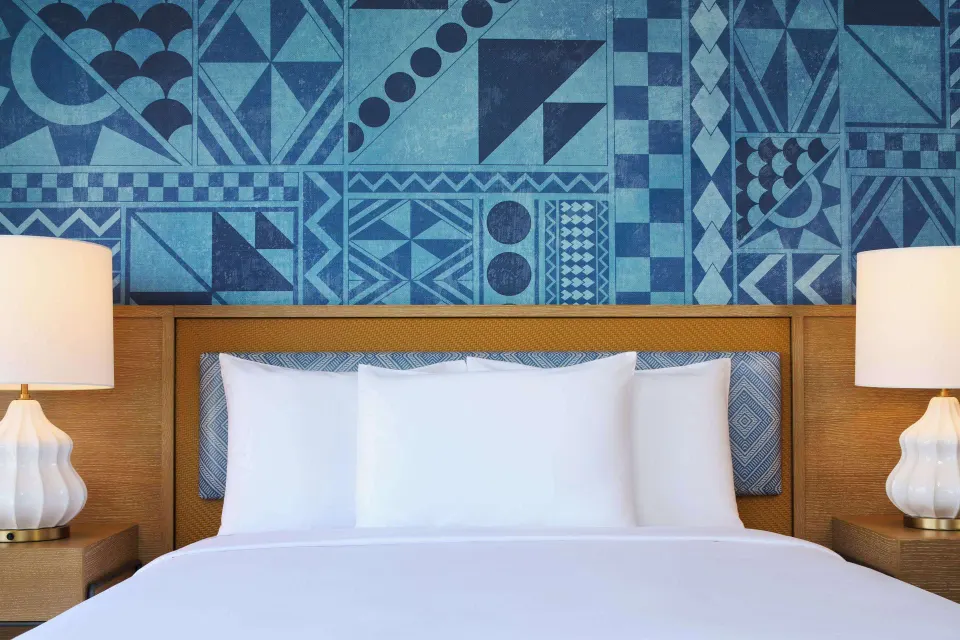 King bed detail with blue patterned wall at OUTRIGGER Waikiki Paradise Hotel.