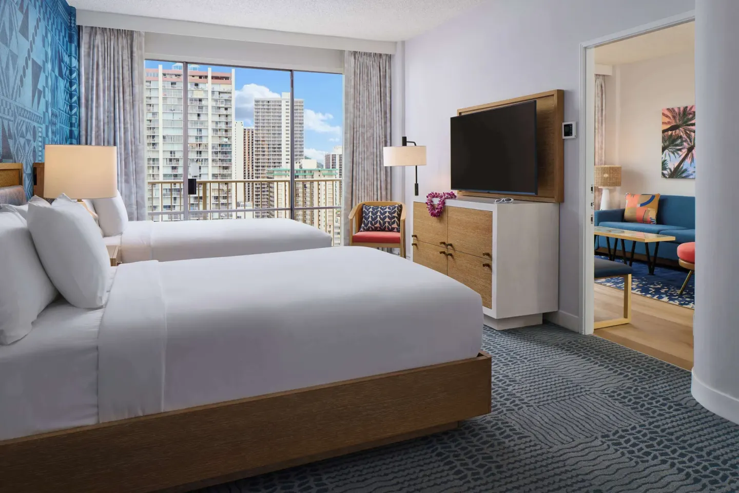 Two-bed guest room with adjoining sitting area at OUTRIGGER Waikiki Paradise Hotel.