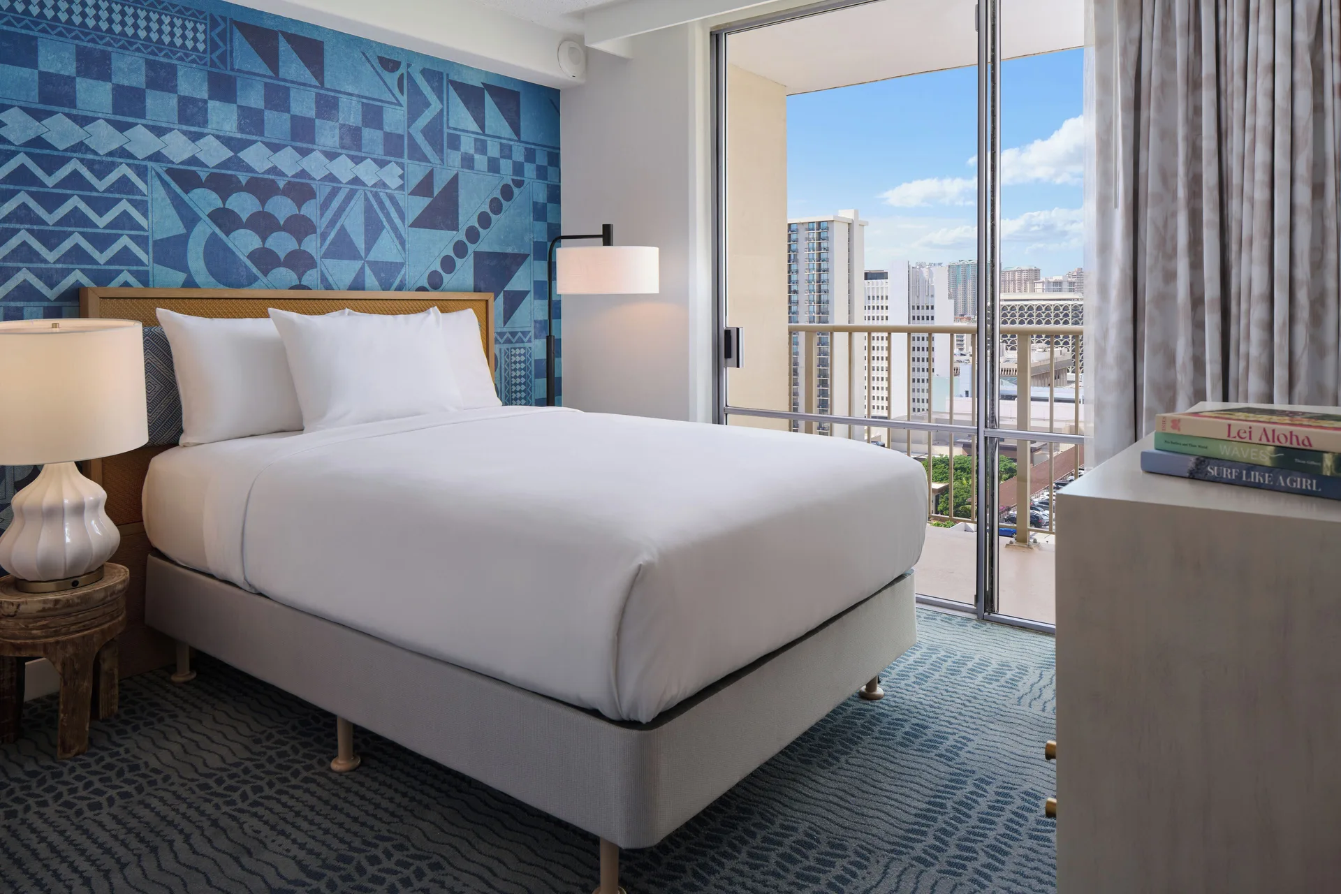 Two-bedroom suite bedroom with king bed and balcony at OUTRIGGER Waikiki Paradise Hotel.