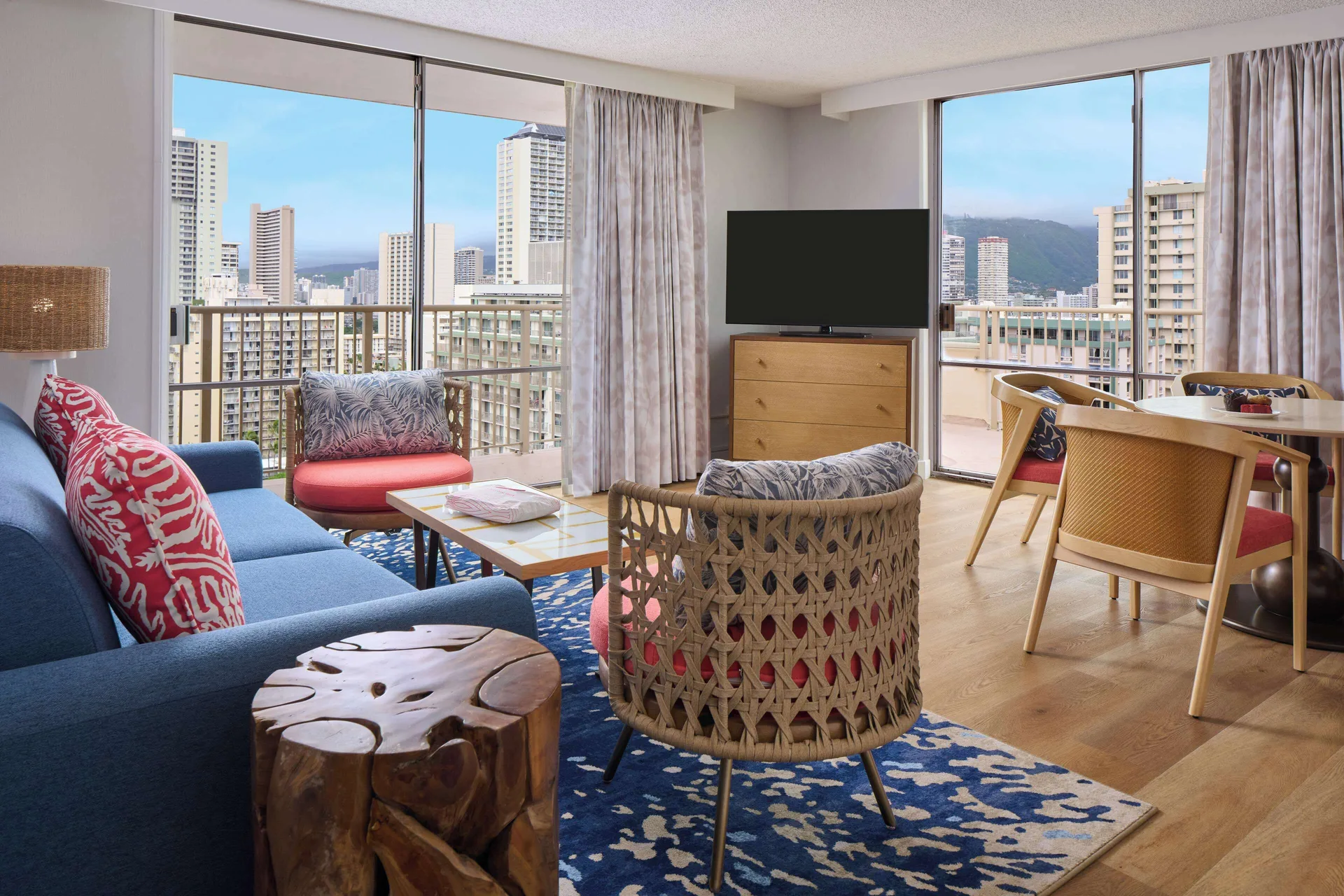 Two-bedroom partial ocean view suite living area at OUTRIGGER Waikiki Paradise Hotel with balcony windows.