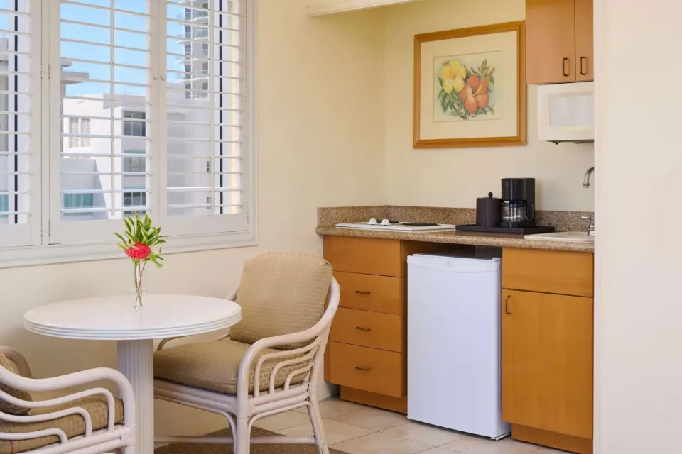 Two Studio with Kitchenette dining nook at OUTRIGGER Waikiki Paradise Hotel with table and mini fridge.