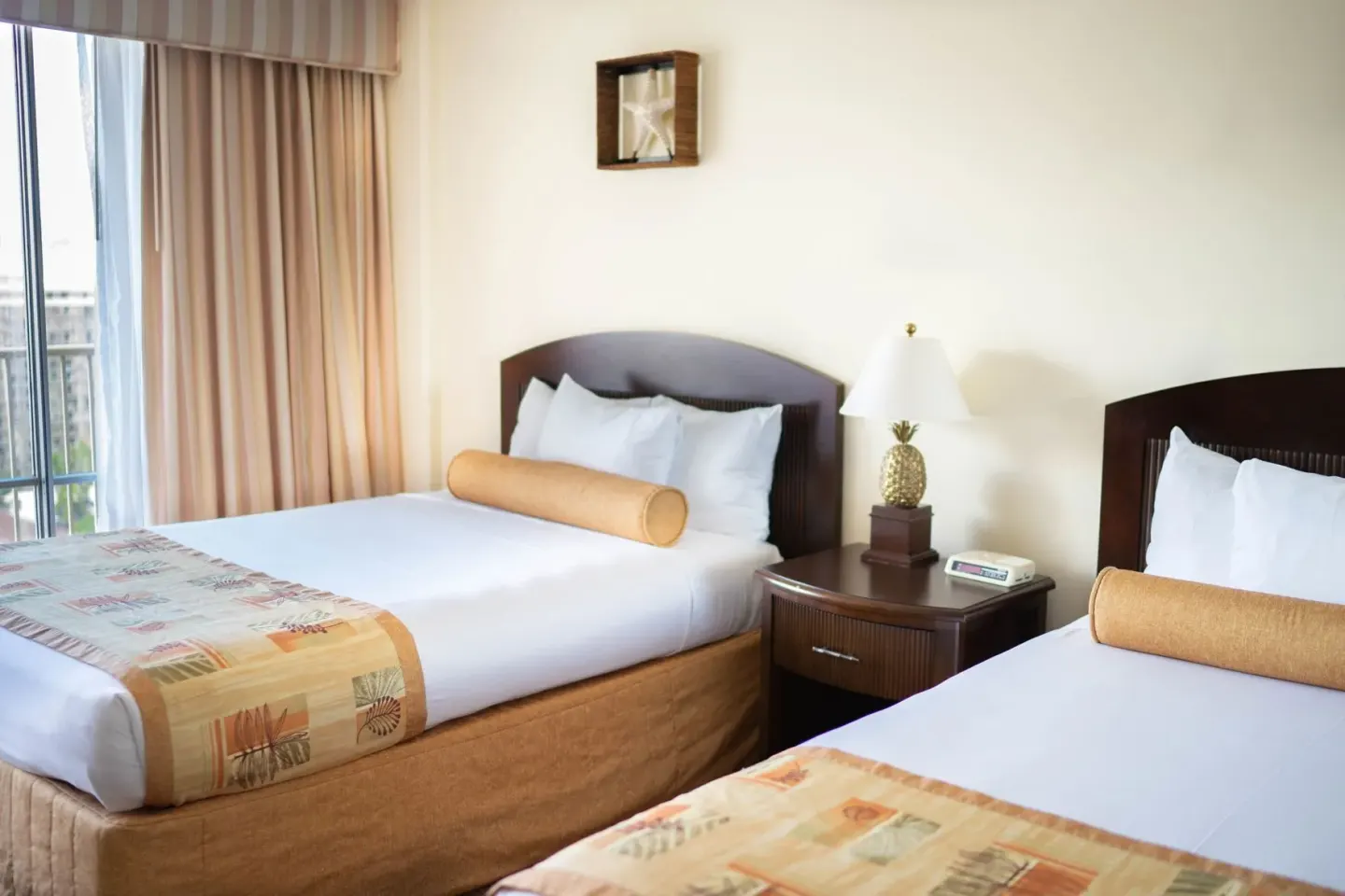 Two Studio with Kitchenette beds at OUTRIGGER Waikiki Paradise Hotel with nightstand and window.