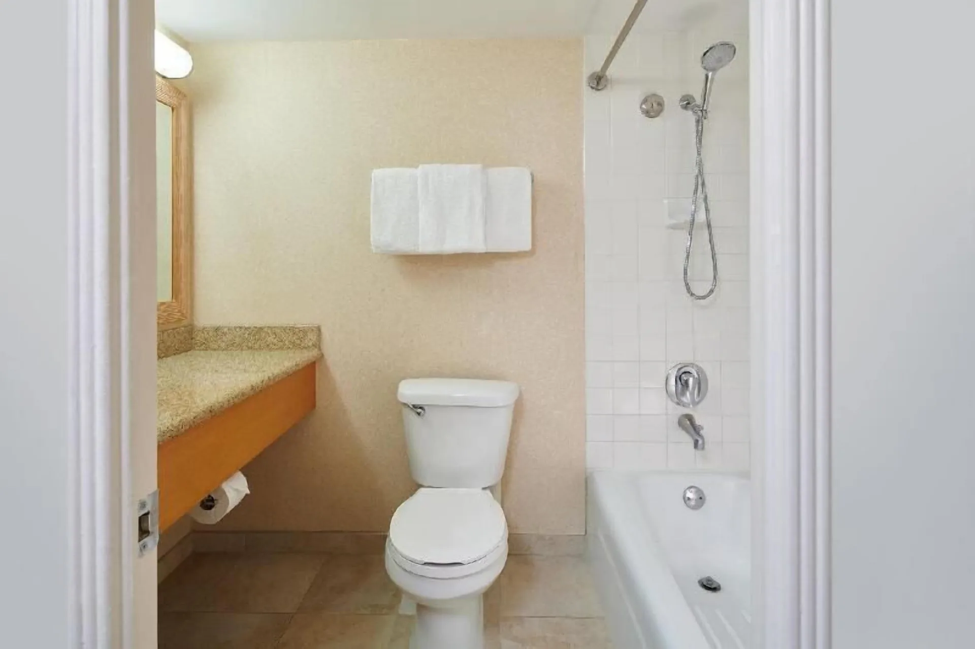 Bathroom with vanity, toilet and tub-shower in a Waikiki Suite at OUTRIGGER Waikiki Paradise Hotel.