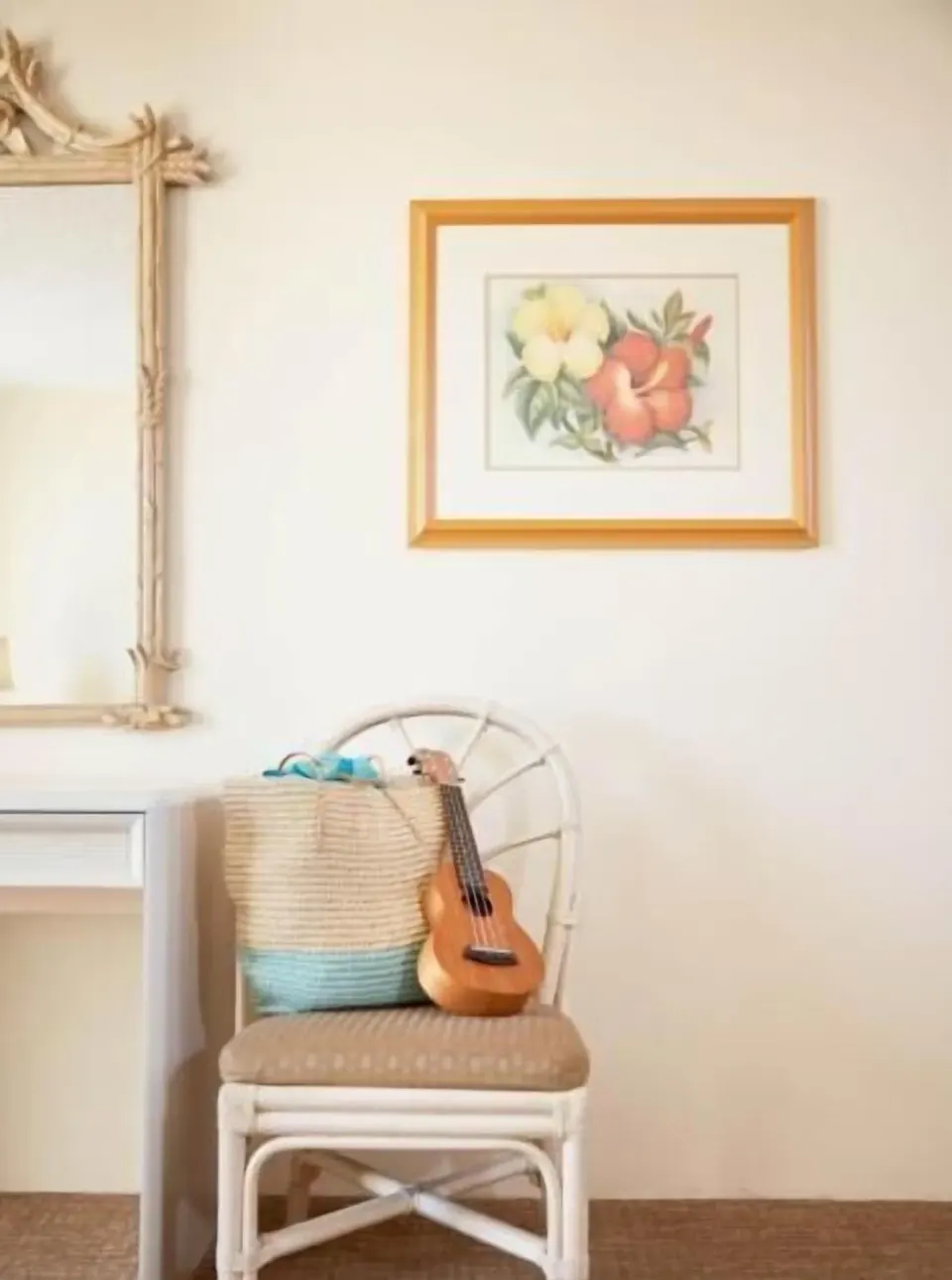 Chair with ukulele and woven tote beside a mirror in a Waikiki Suite at OUTRIGGER Waikiki Paradise Hotel.