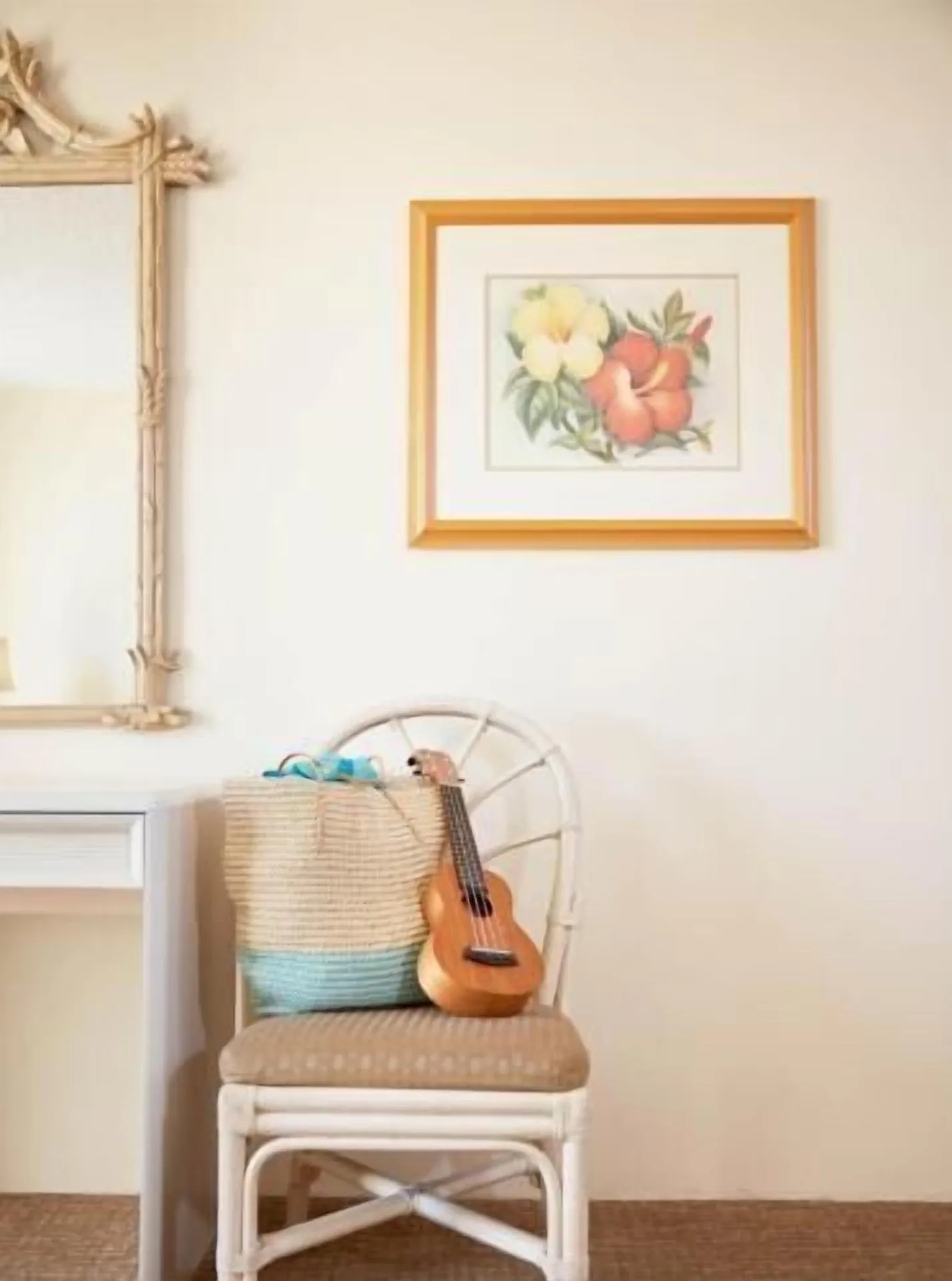 Chair with ukulele and woven tote beside a mirror in a Waikiki Suite at OUTRIGGER Waikiki Paradise Hotel.
