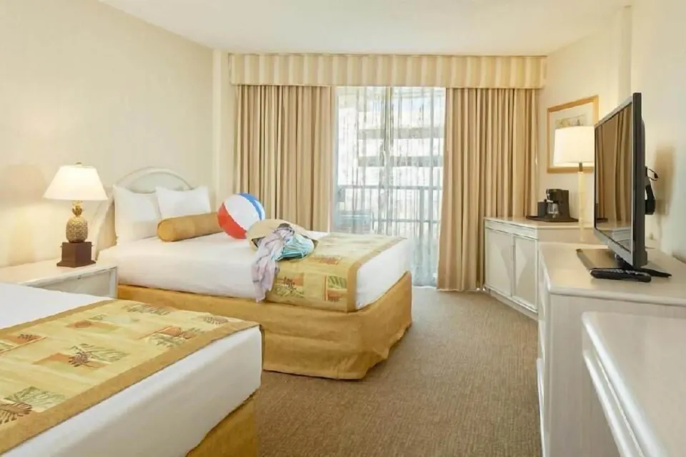 Waikiki Suite View room with two beds and beach items at OUTRIGGER Waikiki Paradise Hotel.