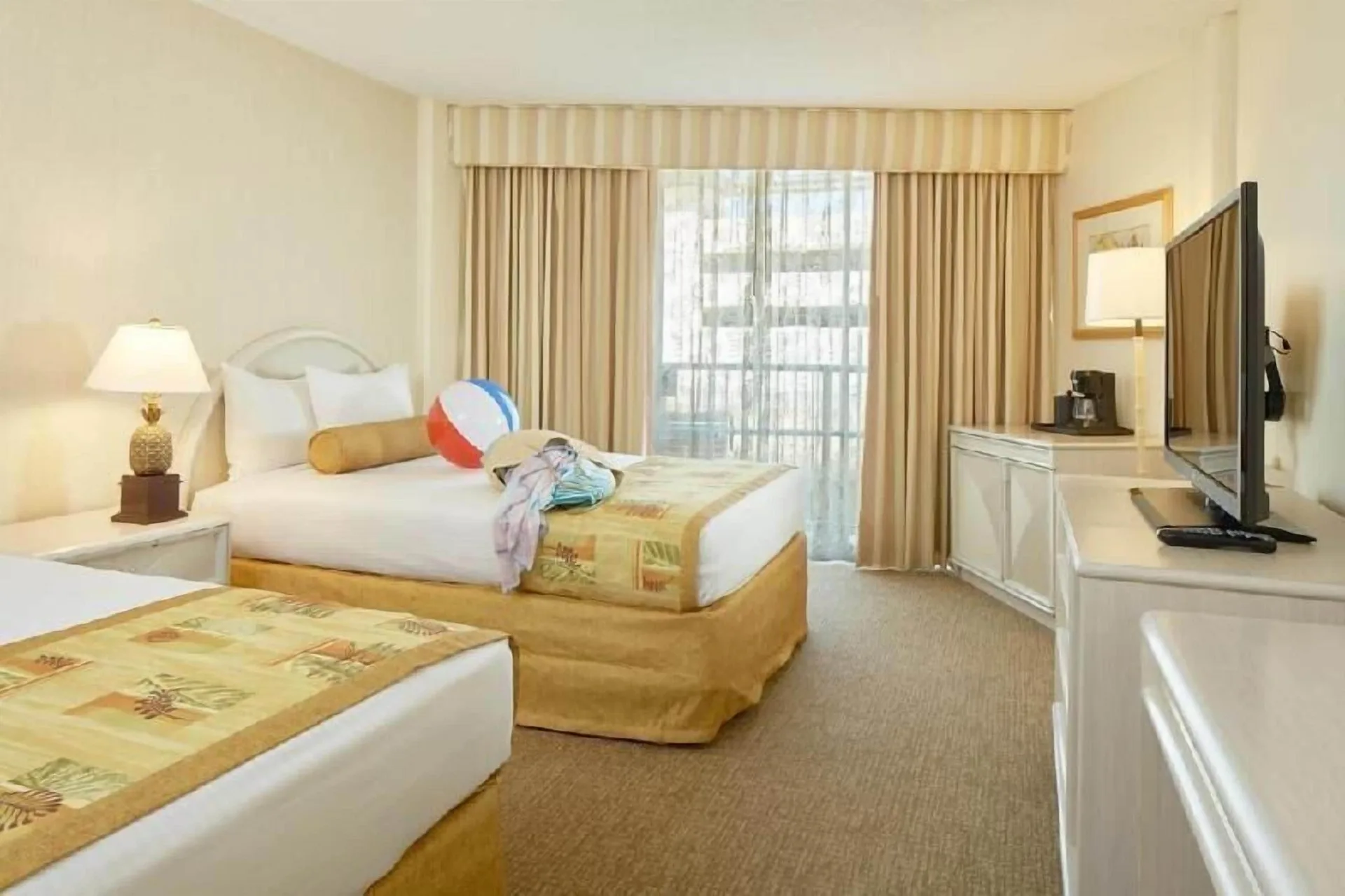 Waikiki Suite View room with two beds and beach items at OUTRIGGER Waikiki Paradise Hotel.
