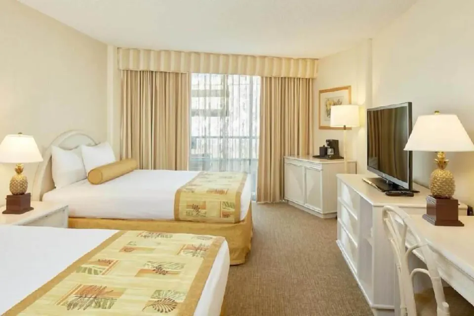 Waikiki Suite View room with two beds, TV, and desk at OUTRIGGER Waikiki Paradise Hotel.