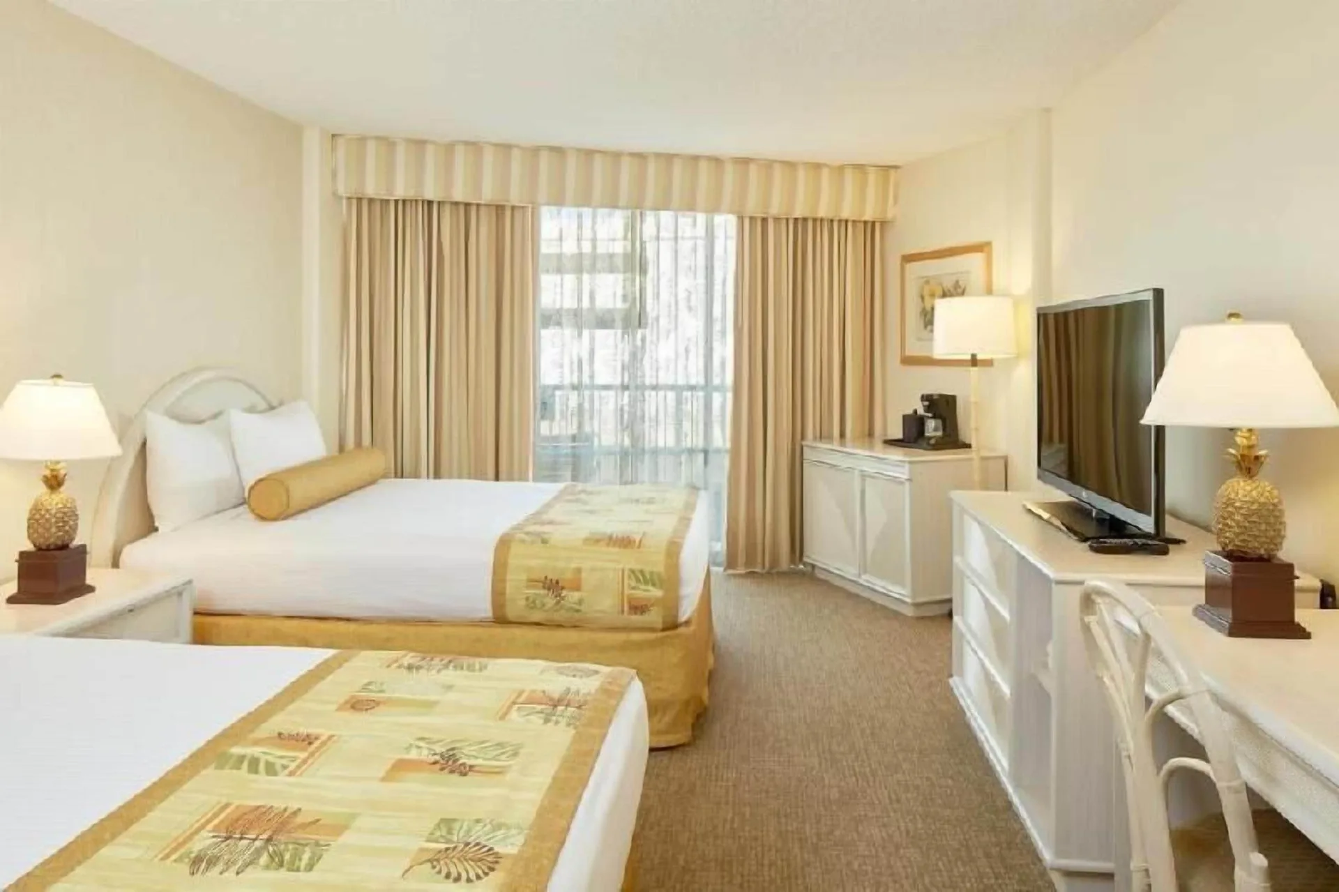 Waikiki Suite View room with two beds, TV, and desk at OUTRIGGER Waikiki Paradise Hotel.