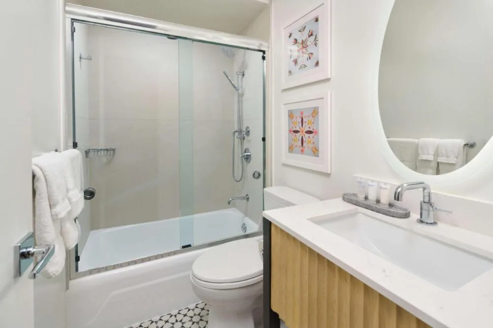 Waikiki View bathroom with tub, glass shower doors, and vanity at OUTRIGGER Waikiki Paradise Hotel.