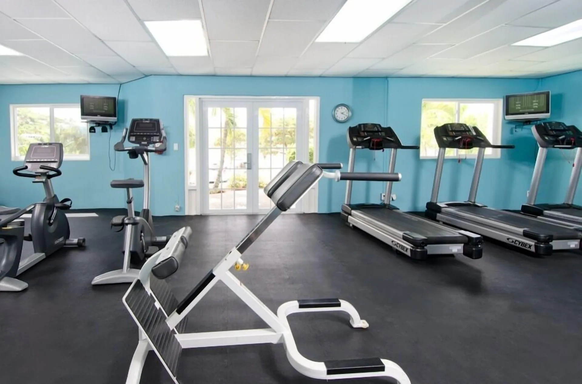 Fitness room with treadmills, bikes, and weight bench at Oyster Bay Beach Resort.