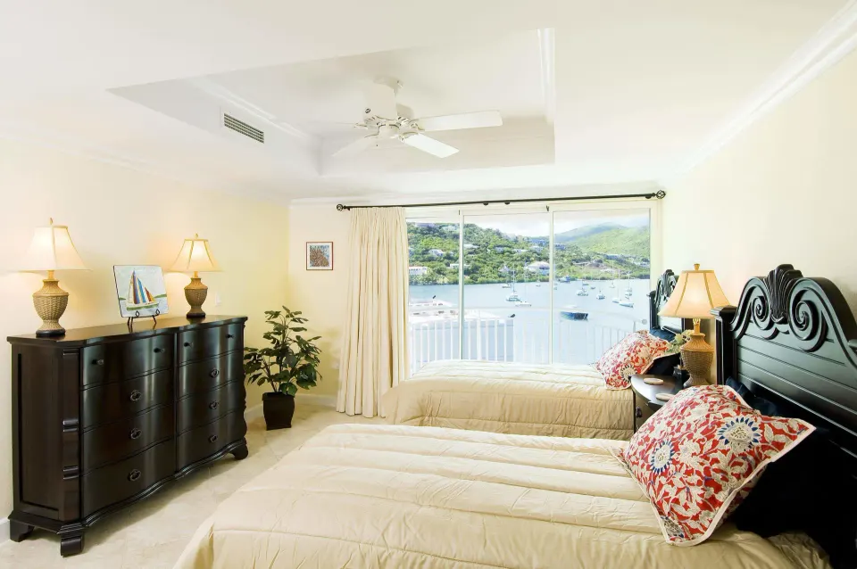Guest bedroom with two beds and a marina view window at Oyster Bay Beach Resort.