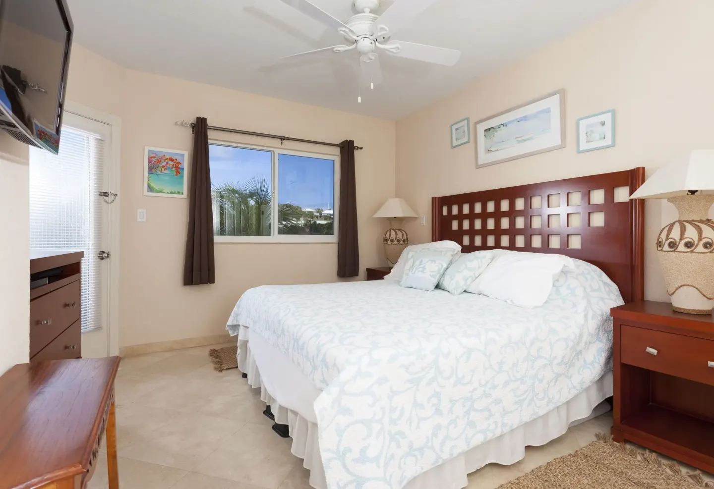 Guest room with a king bed and wood furnishings at Oyster Bay Beach Resort.