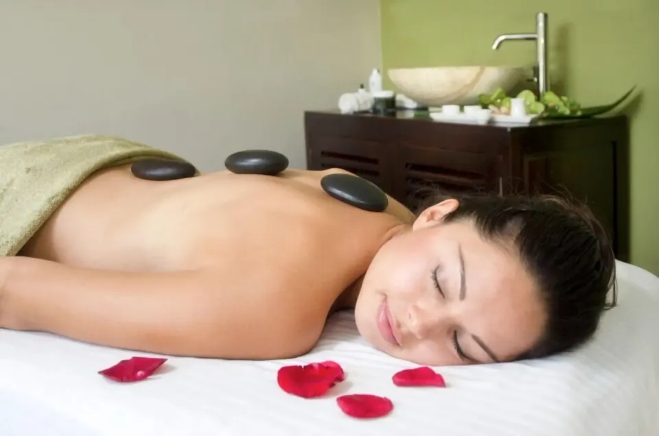 Spa guest receiving a hot stone treatment at Oyster Bay Beach Resort.