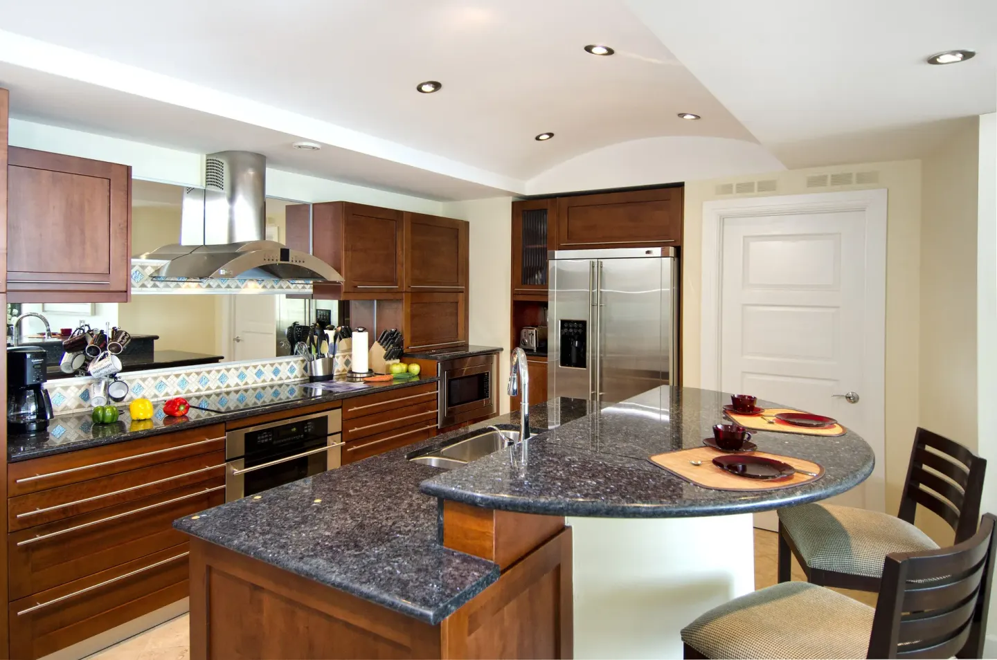 Full kitchen with granite island and dining place settings at Oyster Bay Beach Resort.