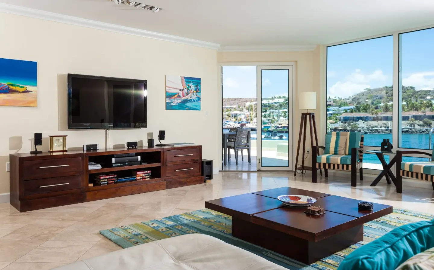 Living room with TV, balcony doors, and marina view at Oyster Bay Beach Resort.