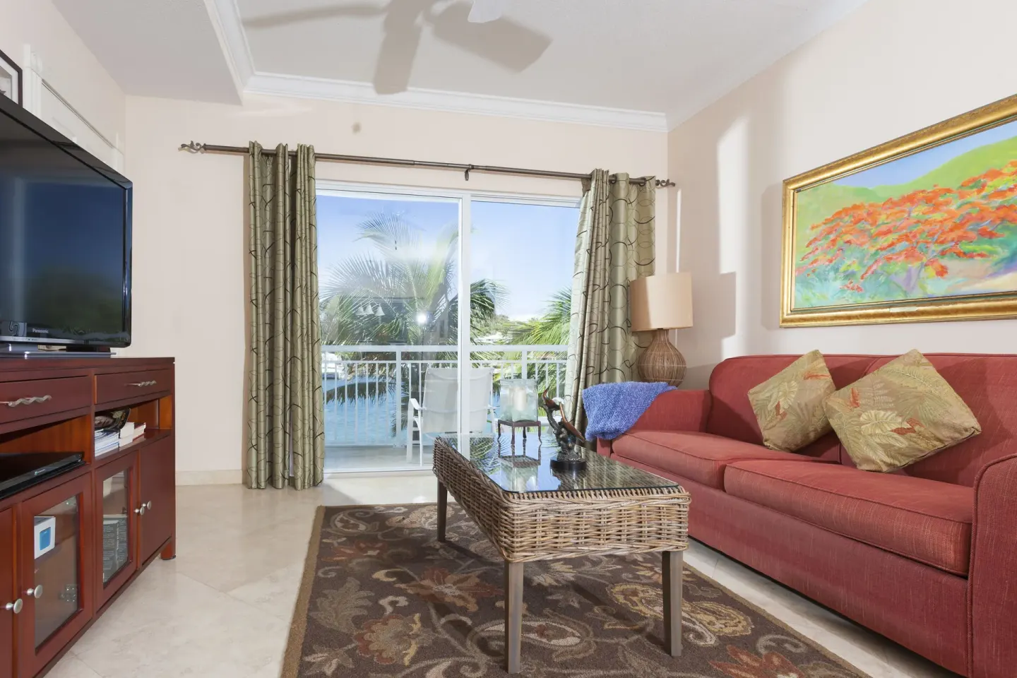 Living room with red sofa and balcony doors at Oyster Bay Beach Resort.