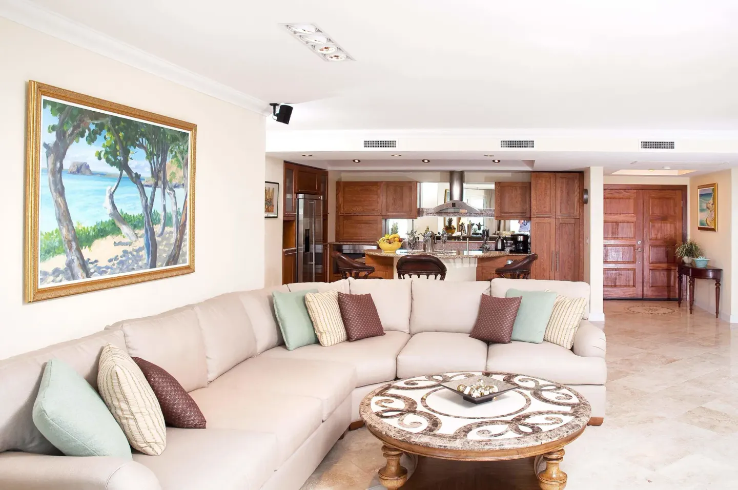 Open living area with sectional sofa and kitchen beyond at Oyster Bay Beach Resort.