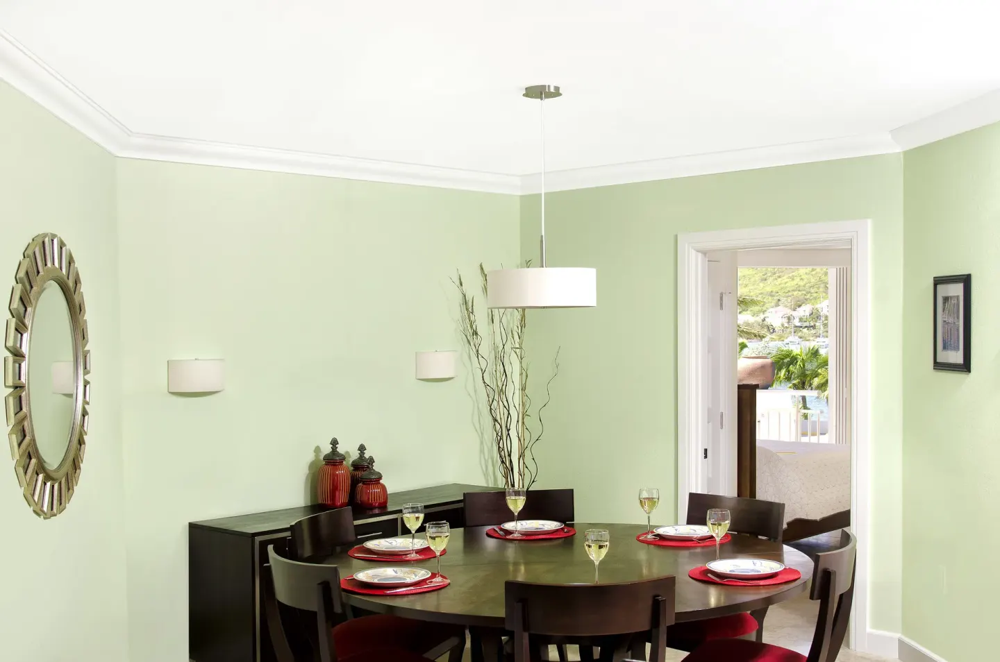 Dining room with a round table and balcony doorway at Oyster Bay Beach Resort.