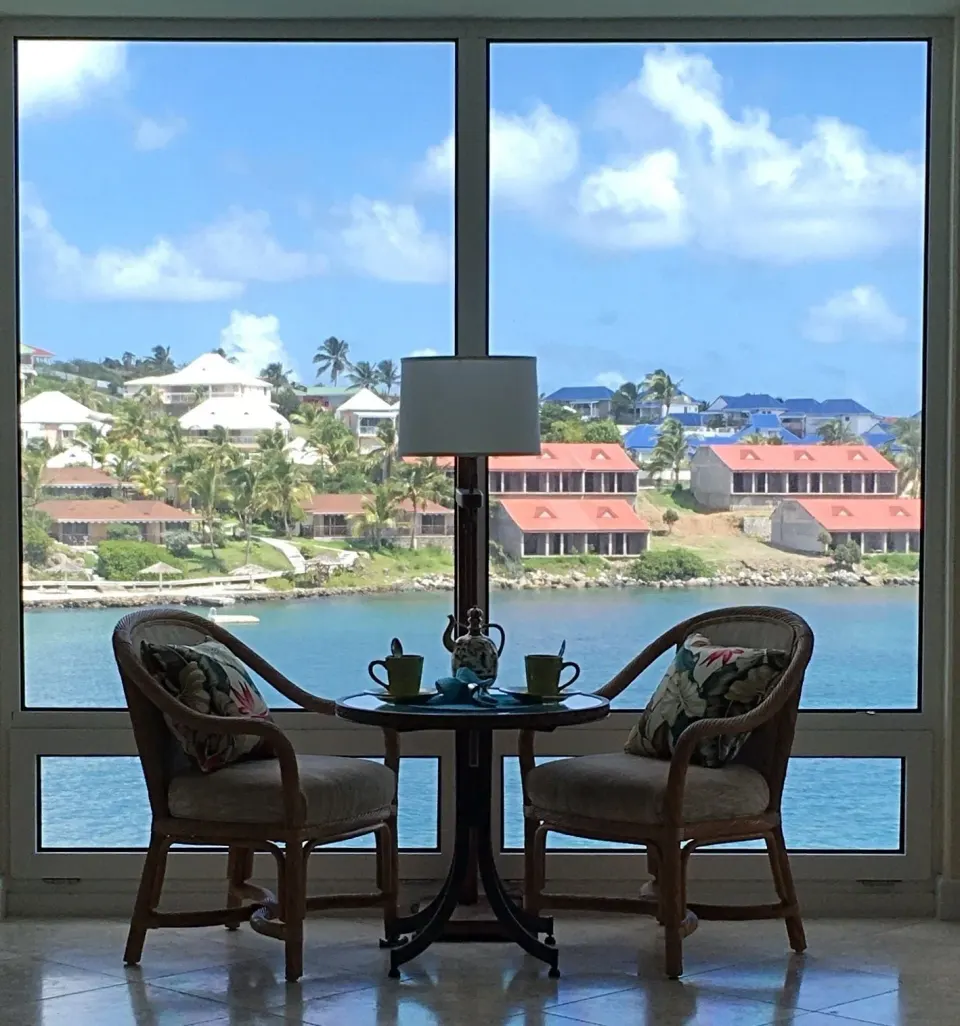 Seating by a large waterfront window at Oyster Bay Beach Resort.